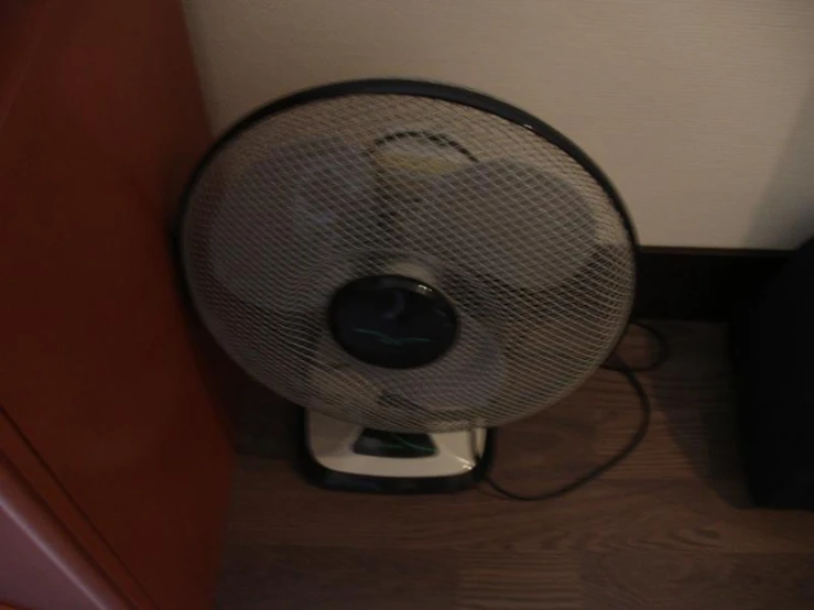 an electric fan with a small light on top of it