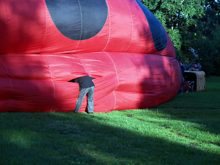a man holding the arm of a giant red balloon