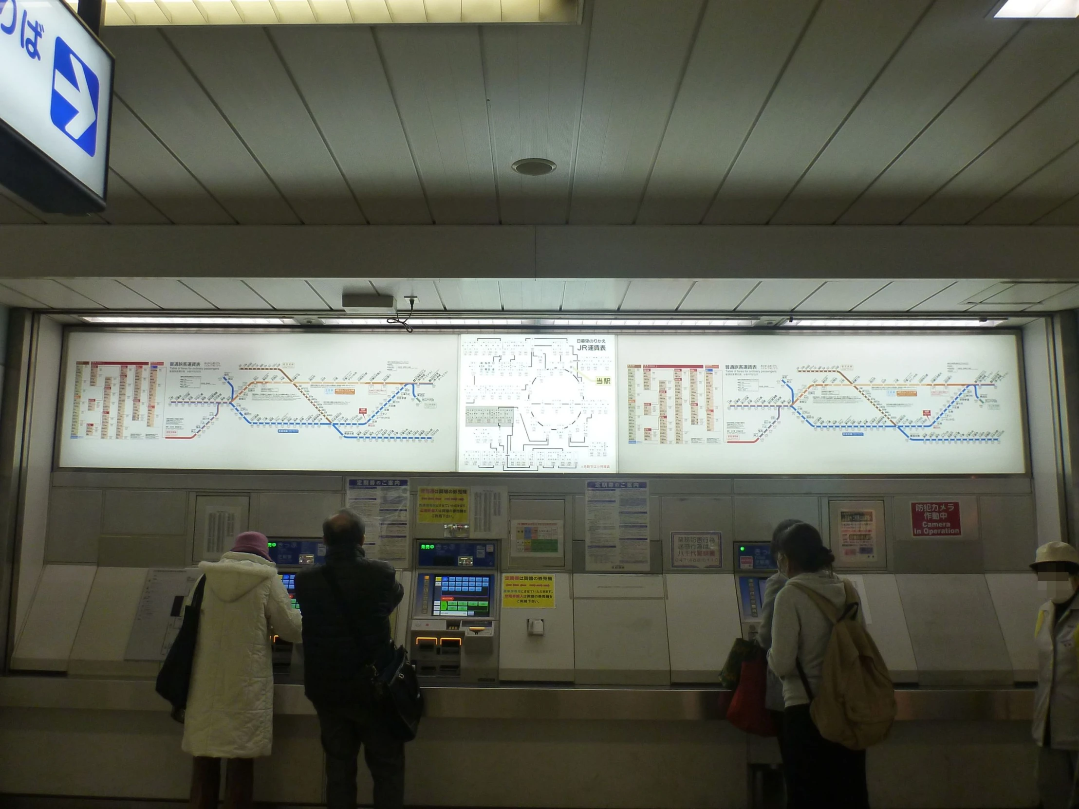 some people standing on the subway next to some posters