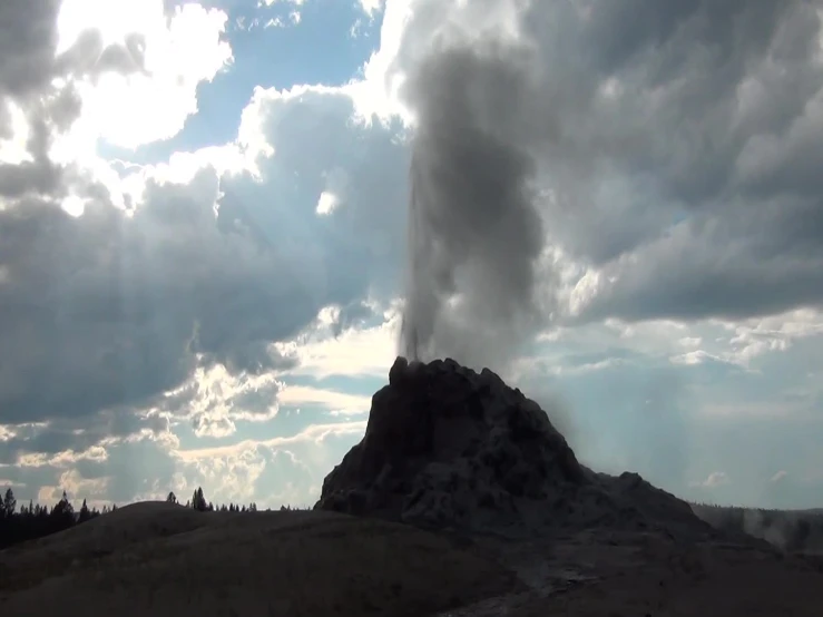 the sun is shining behind a large plume of smoke