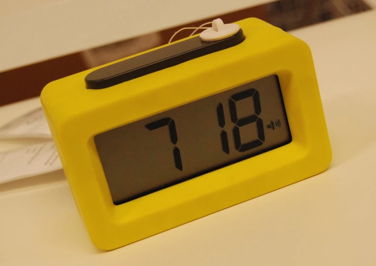 an alarm clock on the counter in front of books
