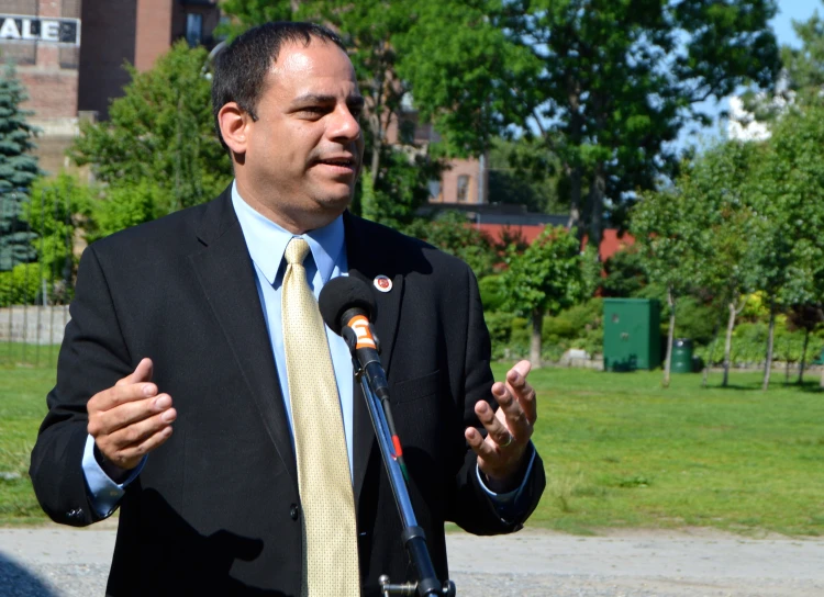 a man holding his hands open while standing by a microphone