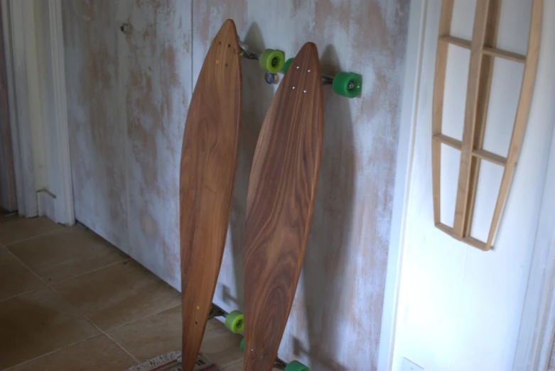 two wooden surfboards are leaning against the wall