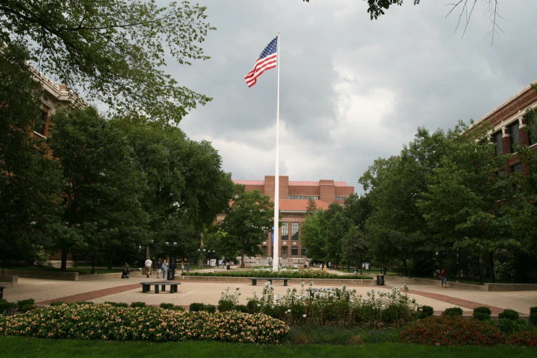 a large flag flying over a park next to a building