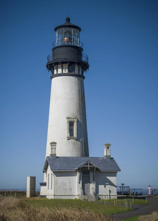 a lighthouse that is on top of some grass