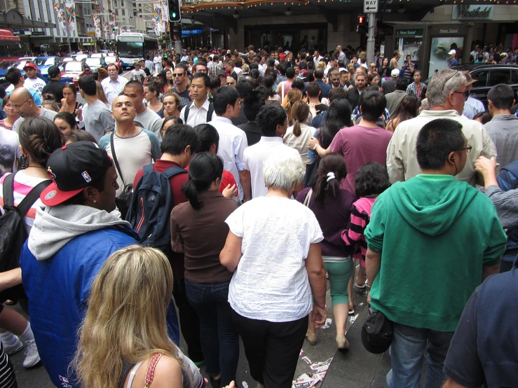 several people are walking down the sidewalk in order to cross