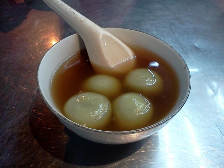 a bowl with some soup in it and a wooden spoon