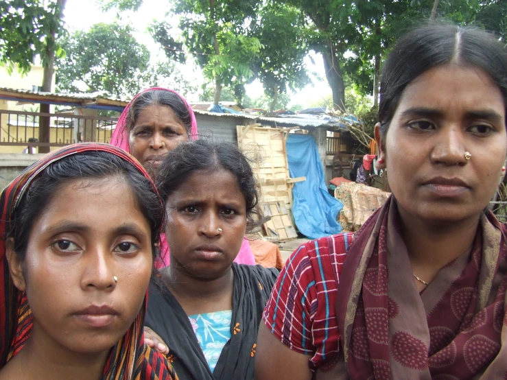 several women wearing colorful scarves pose for a po