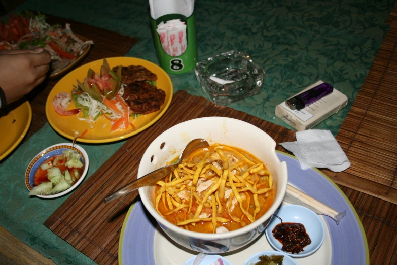 a dish with cheese and meats on it, some drinks are next to the bowls