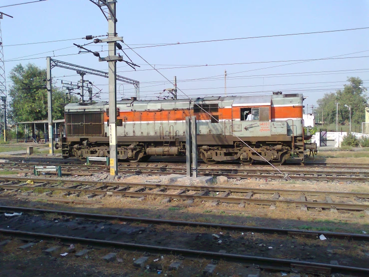 an orange and white train is passing on train tracks