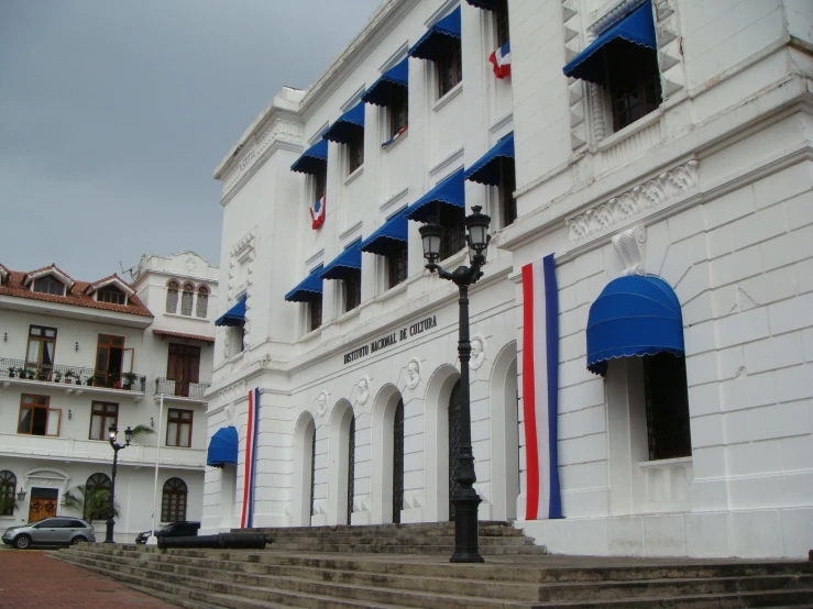 a building in cuba with blue shutters and red white and blue curtains
