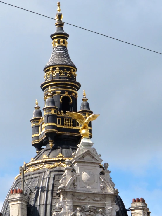 a clock tower that has two gold statues on top