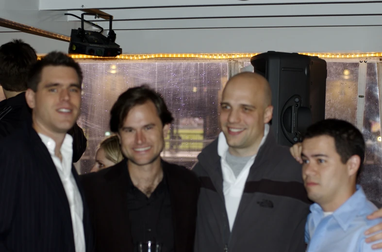 four men are posing for the camera at an event