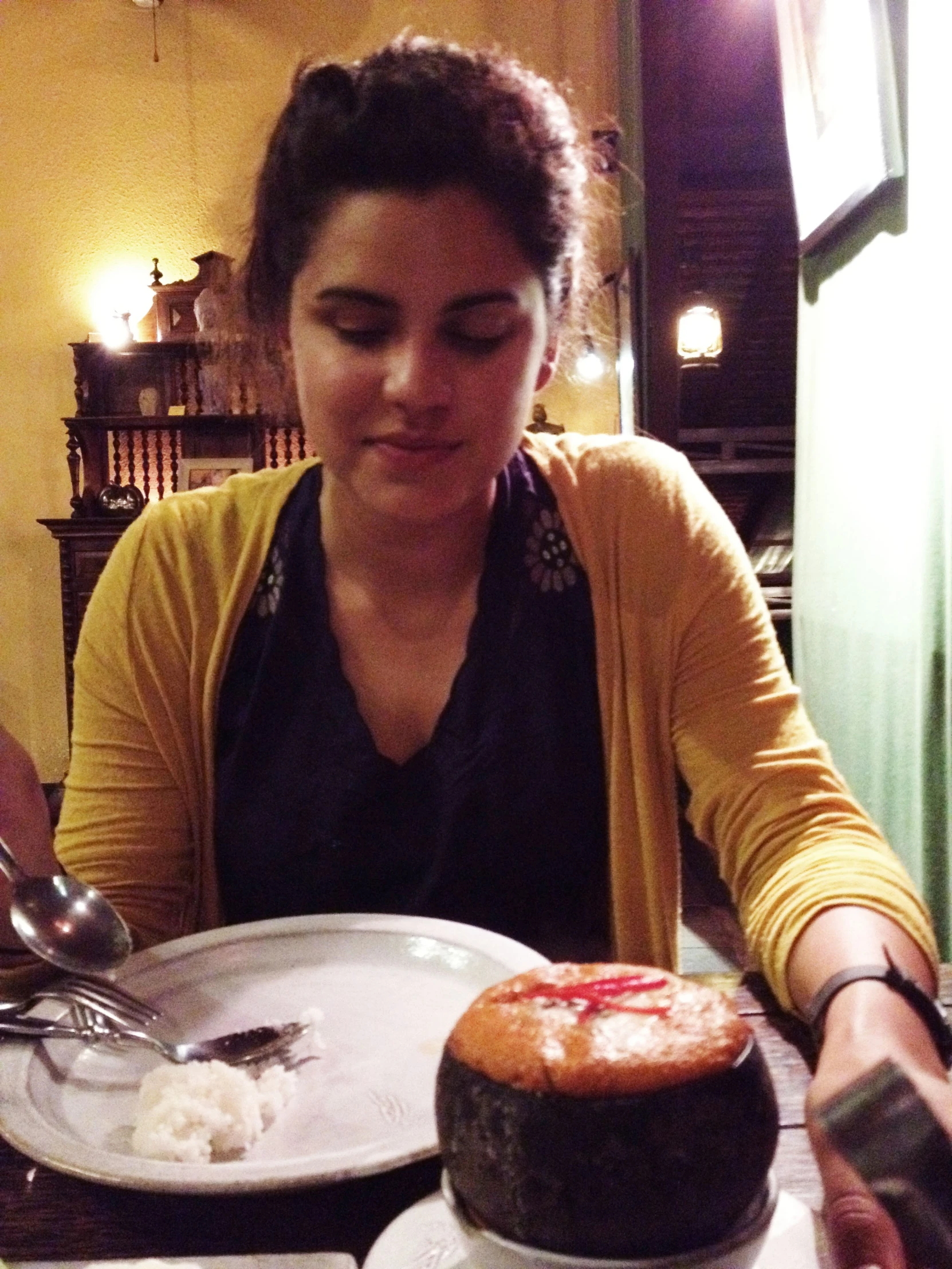 a woman sitting at a table with plates of food