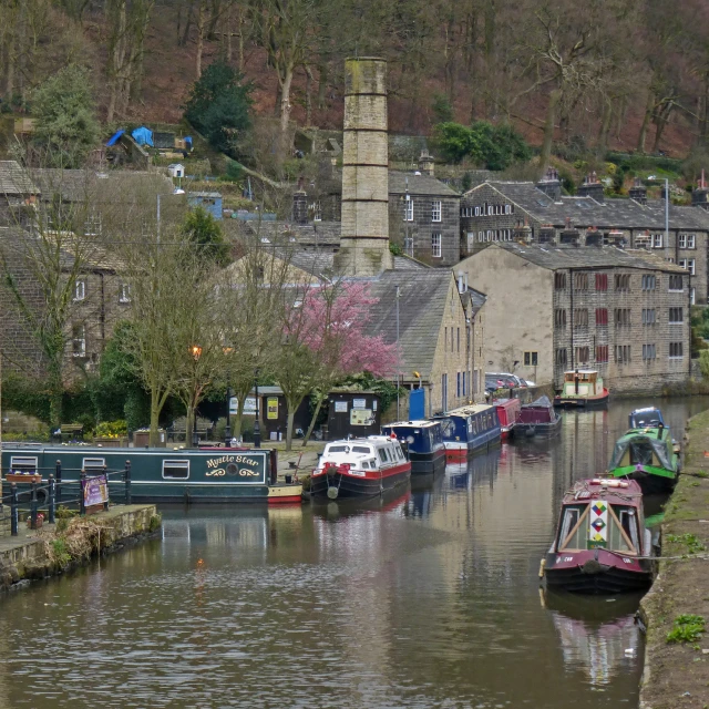 boats docked along a canal next to a village