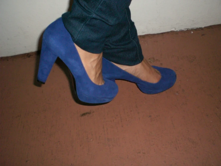 a person wearing high heels standing on a floor