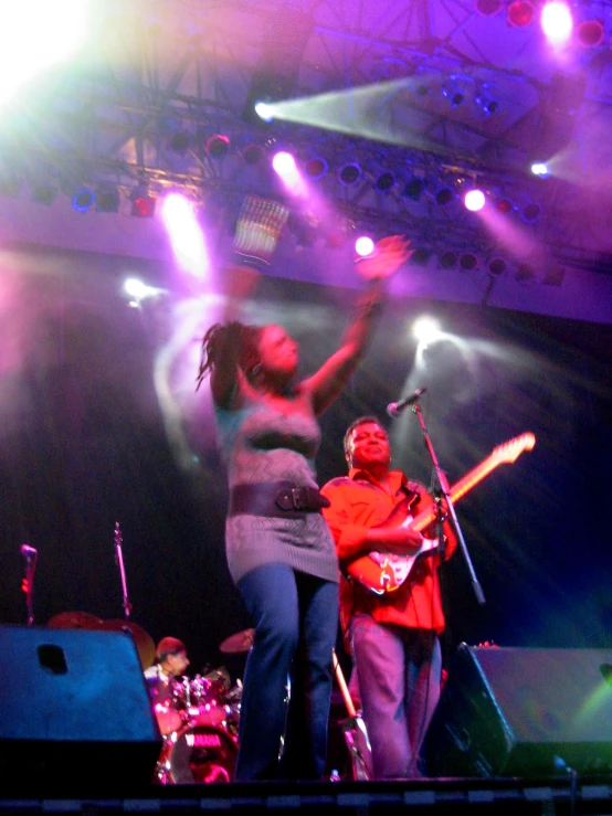 two women dance on a stage together with musical instruments