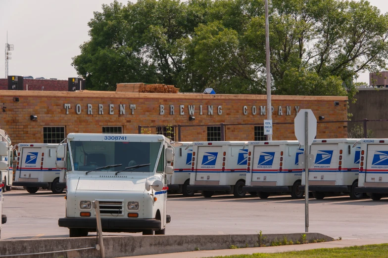 many mail trucks are parked next to a brick building