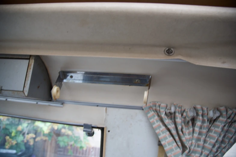 the inside of a camper with a window curtain