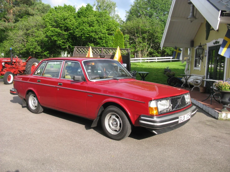 an old fashioned red car parked outside in the driveway