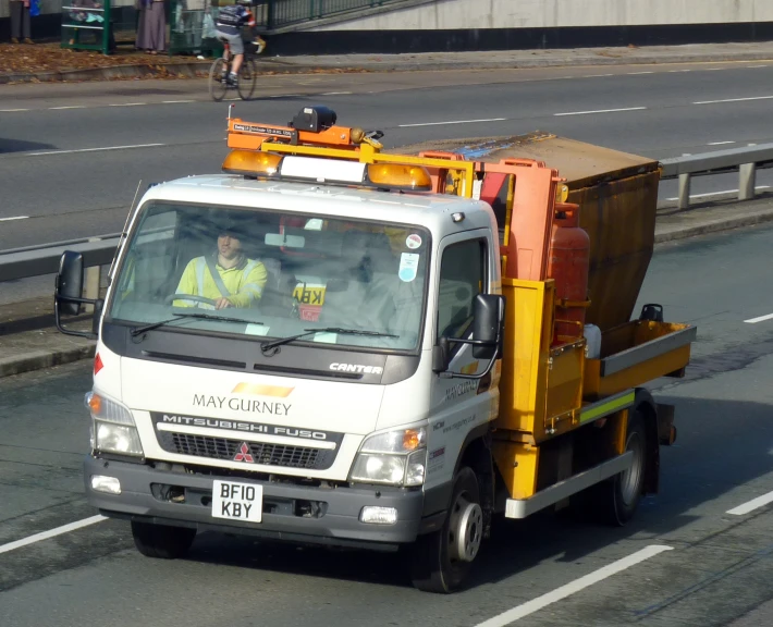 a small truck driving down the street near an intersection