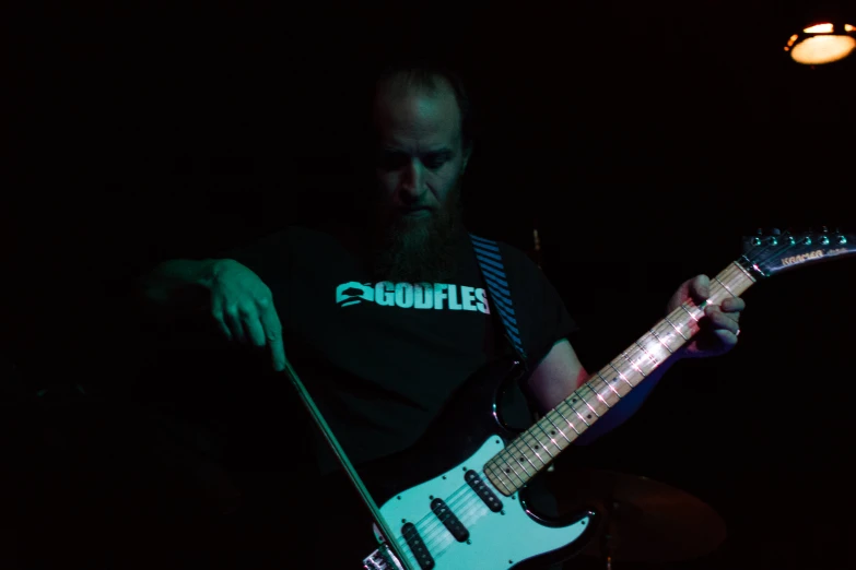 a man is playing the guitar in the dark