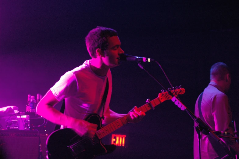 the man is singing and playing the guitar