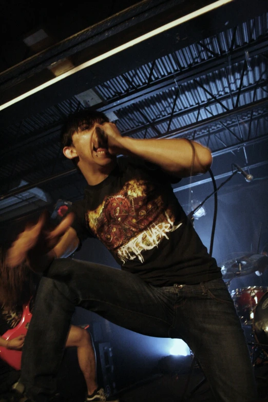 a man singing into a microphone while holding a remote control