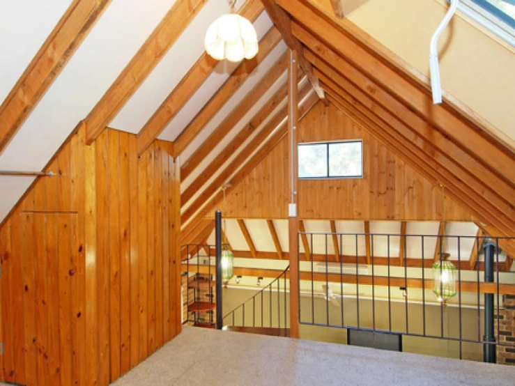 a loft has an open attic with wooden walls