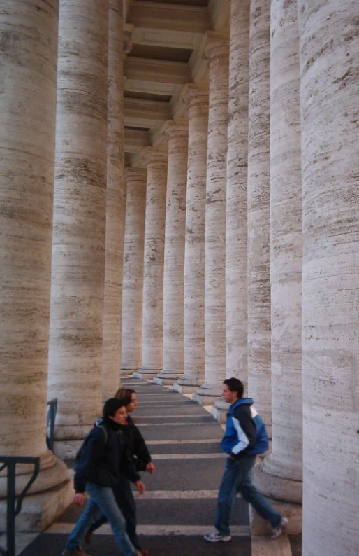 two people walking next to several stone pillars