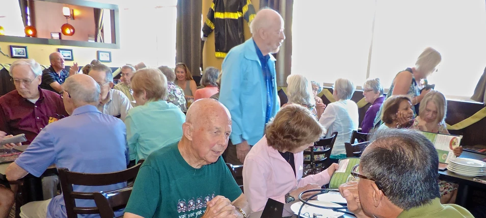 older men and women sitting at a table eating food