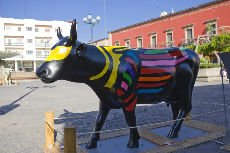 there is a cow that has been painted on and it's sitting on a square