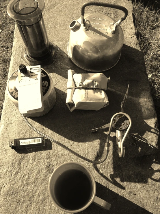 a kettle, measuring cup and some other items on concrete