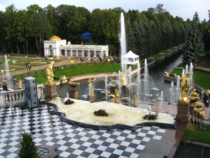 an outdoor area with a fountain, statues and water