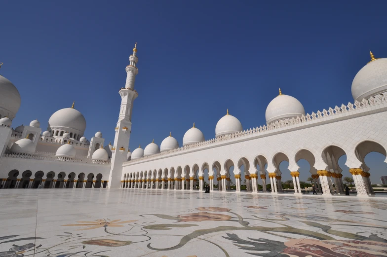 a large white mosque has four tall towers