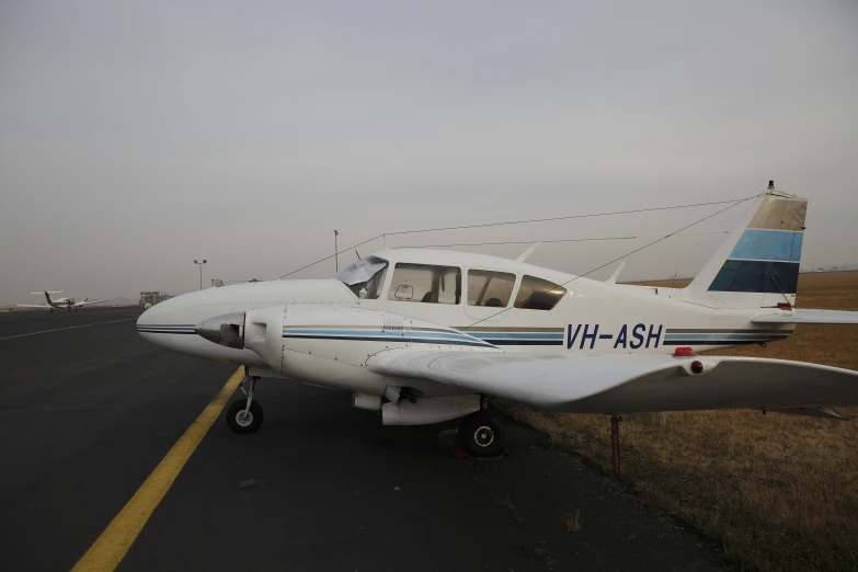 a small propeller plane parked on the side of a runway