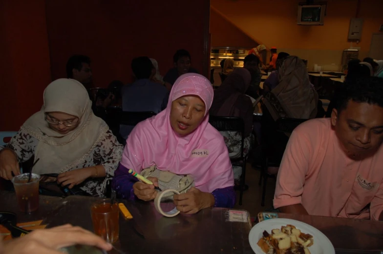 some women are sitting at a table with some plates