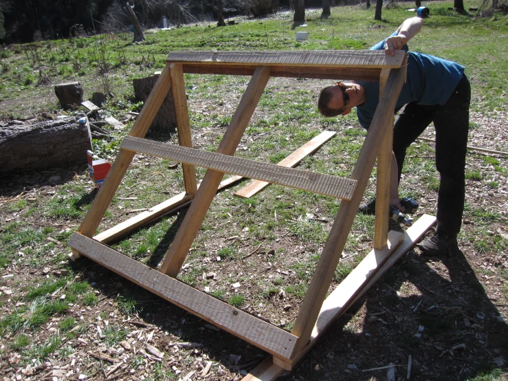 a person standing up and holding on to a wooden frame