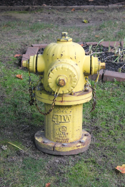 there is a yellow fire hydrant that has a chain hanging off the top