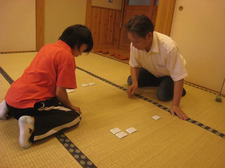 two people kneeling on the floor and playing games
