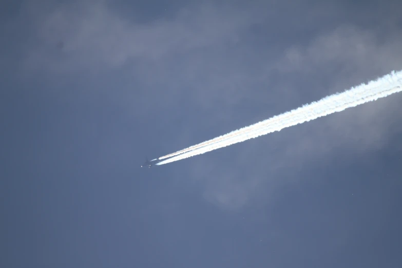 a jet that is flying in the sky with a cloud