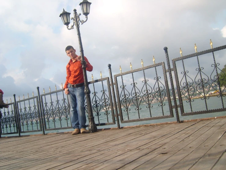 a man standing next to a fence while using his cell phone