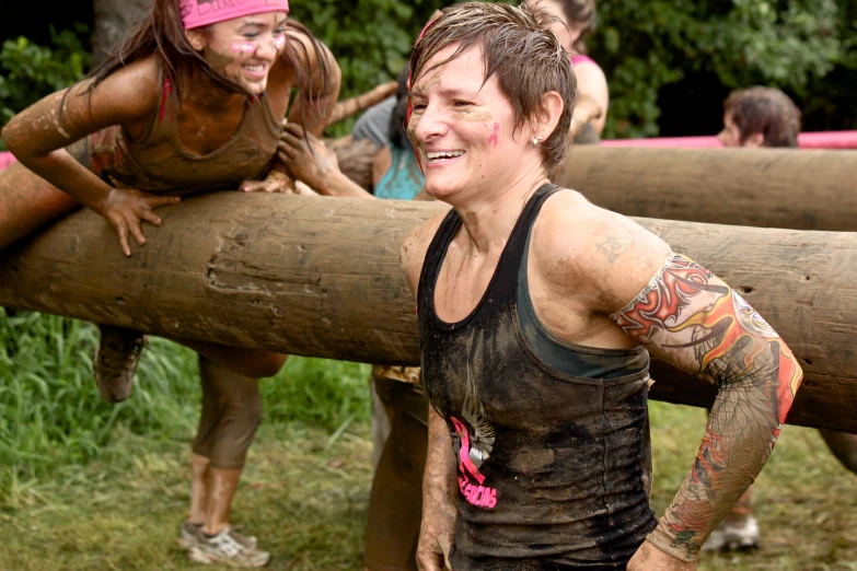 a woman is playing in the mud with some logs