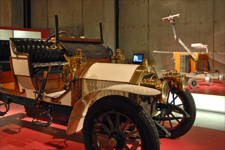 an antique car with gold trim sitting on display