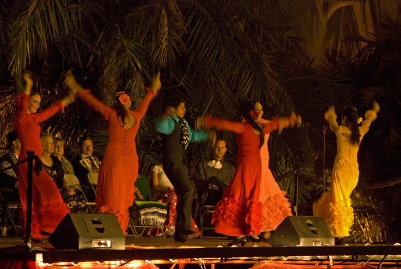 many women and men are dancing on stage