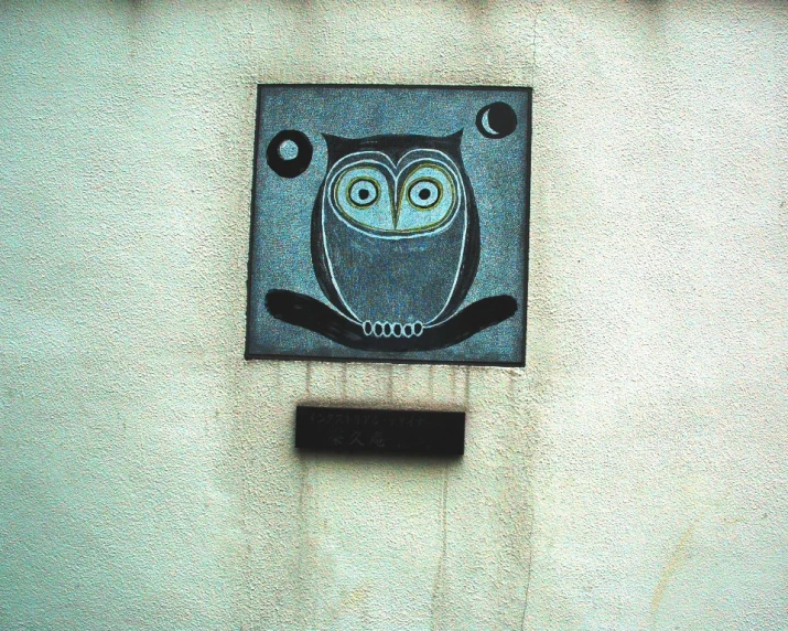an owl is on the side of a building