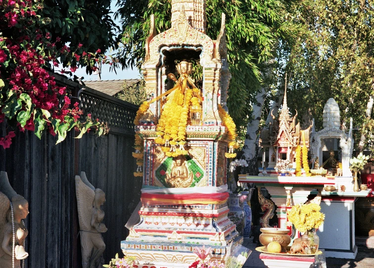 several colorful statues sit outside next to a fence