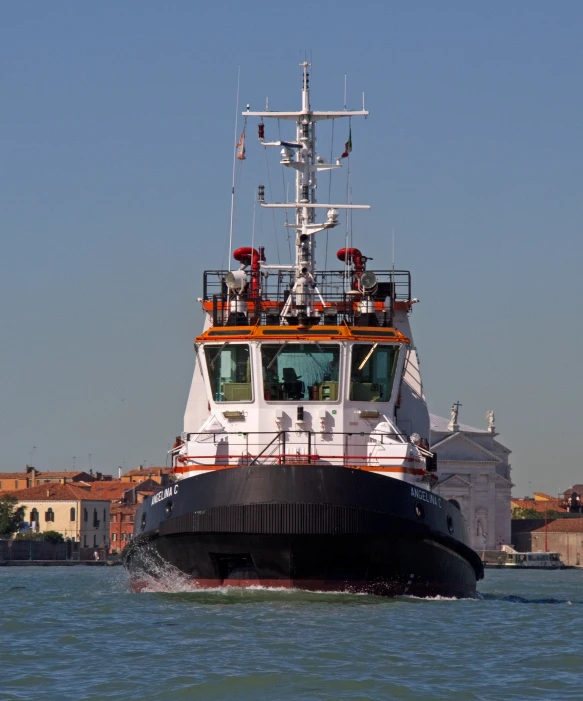 large boat in body of water near buildings