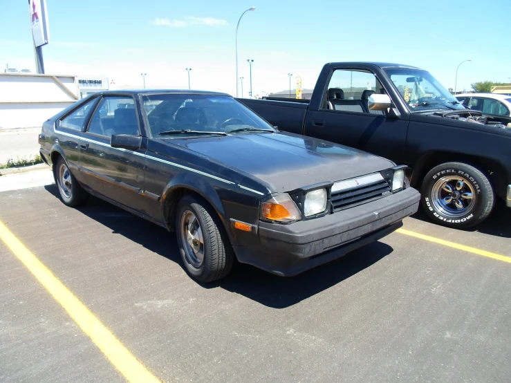 a car parked next to a truck on a parking lot