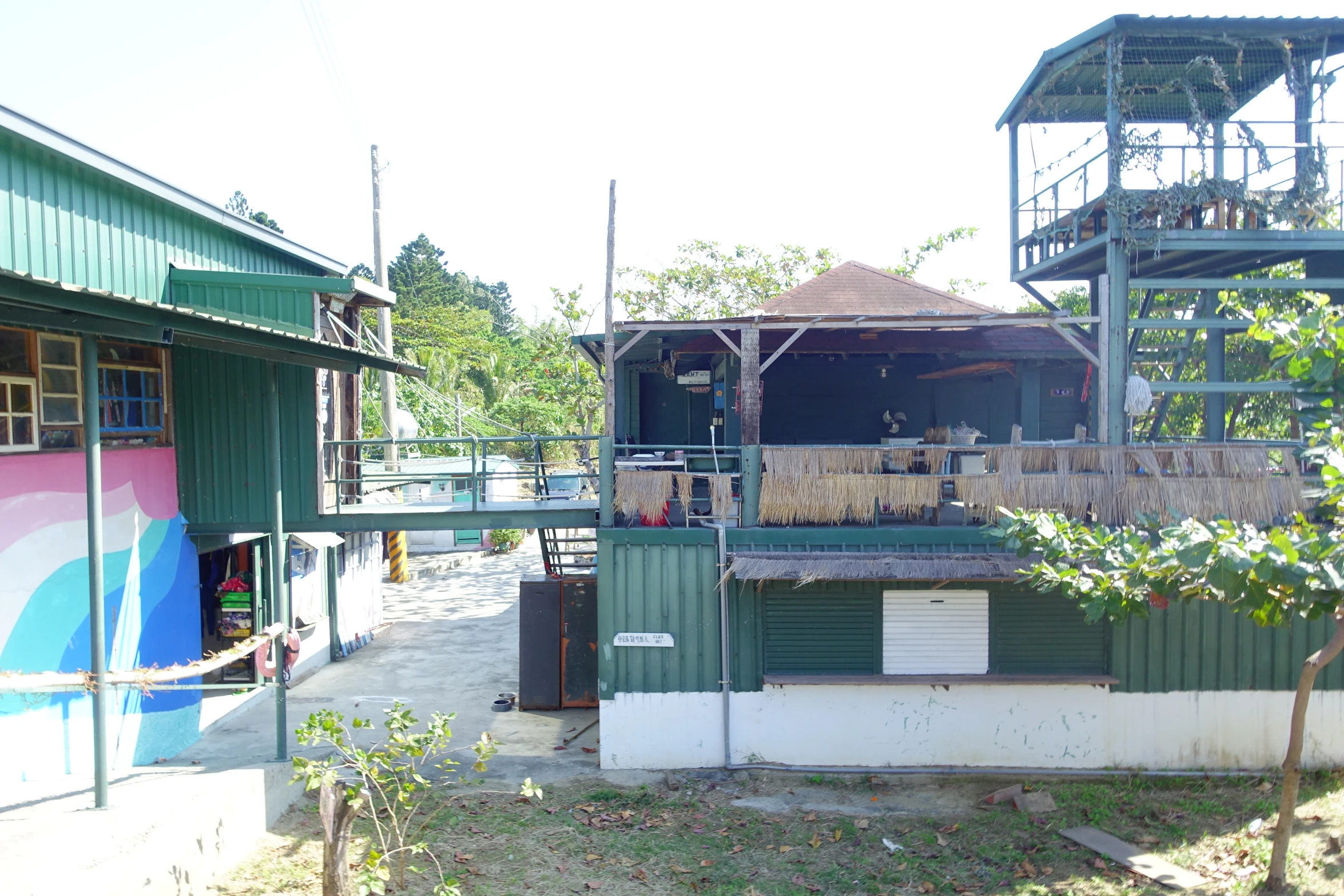 a green house with an outdoor stage is in a backyard